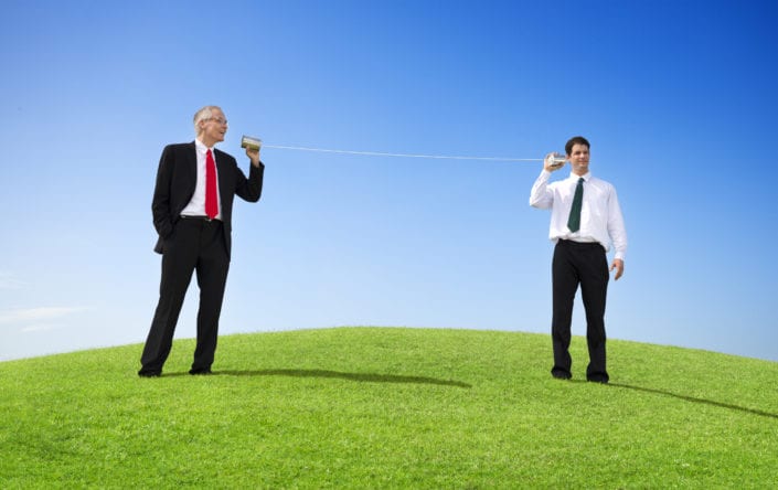 Business Men Outdoors Talking Through Tin Can Phone
